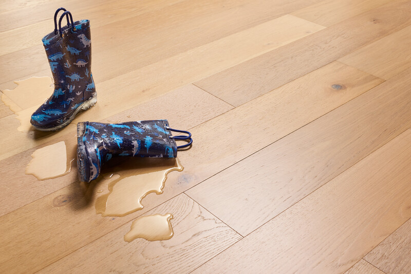 Closeup of boots with water on Hydropel waterproof engineered hardwood flooring